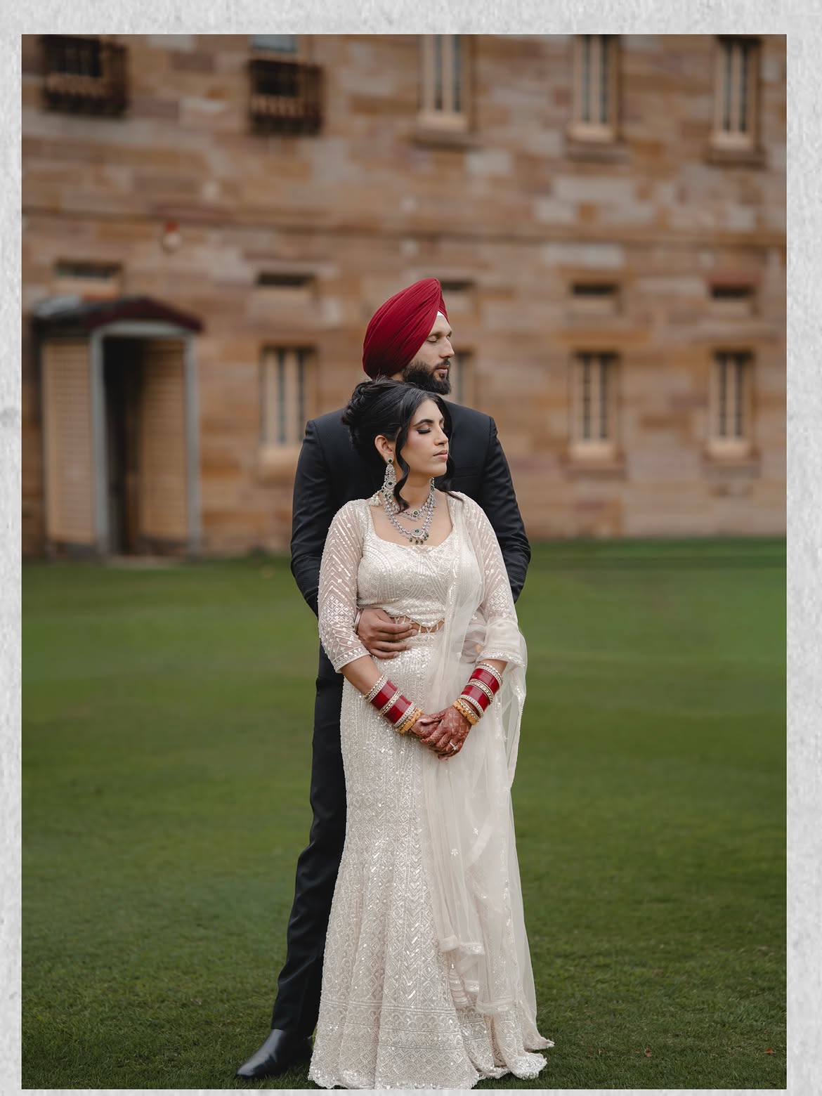 Bride and groom together outside a sandstone building